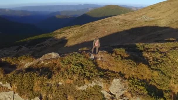 Luchtfoto van Hiker Man met rugzak op de top van een berg — Stockvideo