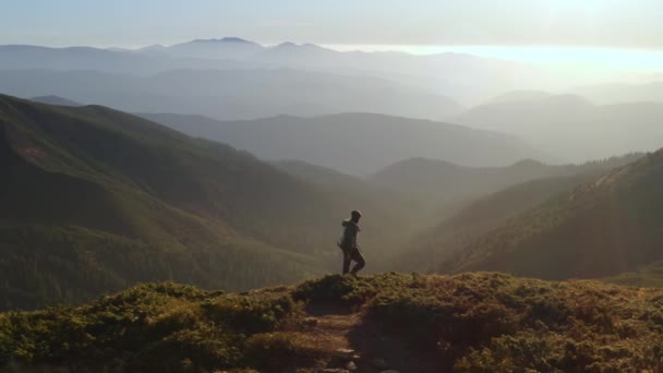 Vista aérea del hombre excursionista con mochila en la cima de una montaña — Vídeo de stock