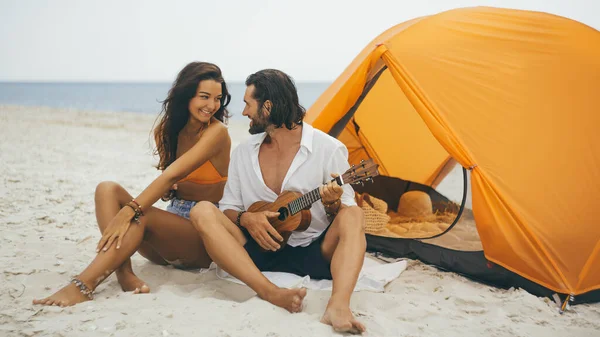 Romantisch koppel in de buurt van een tent aan het strand — Stockfoto