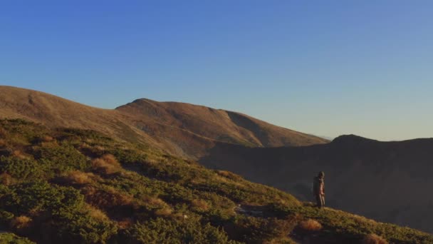 Vista aérea del hombre excursionista con mochila en la cresta de una montaña — Vídeo de stock