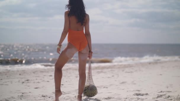 Kobieta w stroju kąpielowym z arbuzem na plaży na świeżym powietrzu — Wideo stockowe