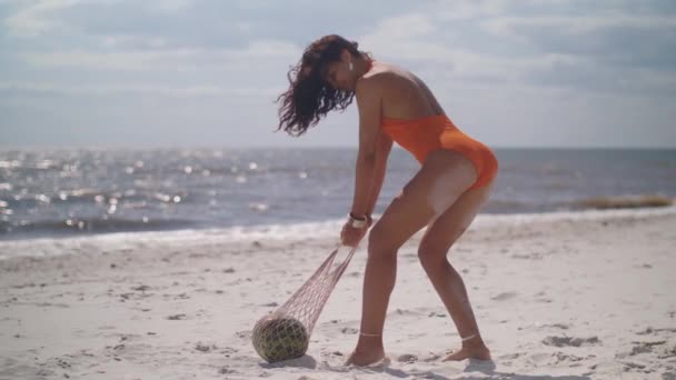 Vrouw in badpak met watermeloen op het strand buiten — Stockvideo