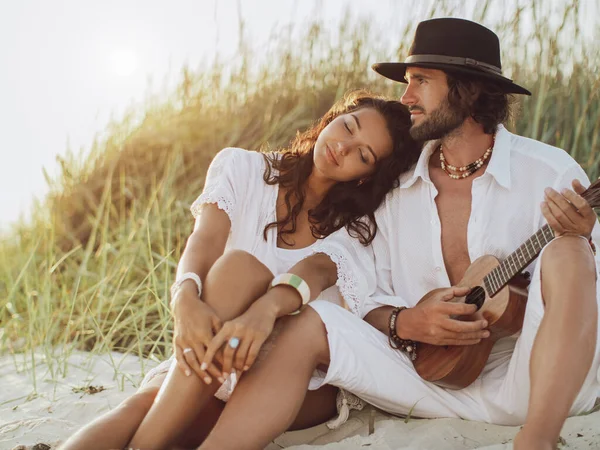 Coppia innamorata che suona la chitarra e riposa sulla spiaggia — Foto Stock