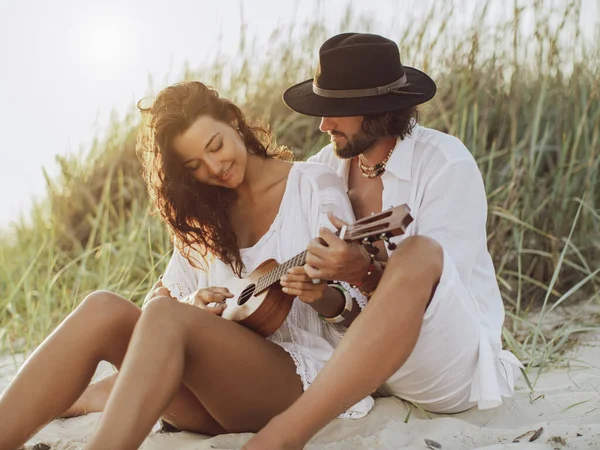Coppia innamorata che suona la chitarra e riposa sulla spiaggia — Foto Stock