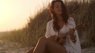 Deniz kenarındaki yaz tatilinde Ukulele 'li Kadın