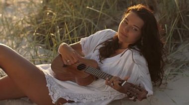 Deniz kenarındaki yaz tatilinde Ukulele 'li Kadın