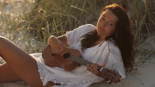 Vrouw met ukelele tijdens zomer strand vakantie in de buurt van de zee — Stockvideo