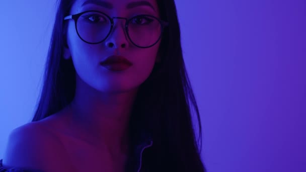 Studio Porträtt av asiatisk kvinna med neonljus. — Stockvideo