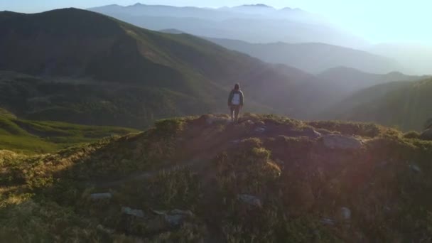 Vista aérea del hombre excursionista con mochila en la cima de una montaña — Vídeo de stock