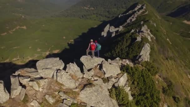 Bir dağın tepesinde sırt çantalı bir çift turistin hava görüntüsü — Stok video