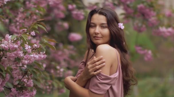 Frau am blühenden Sakura-Baum in der Natur — Stockvideo