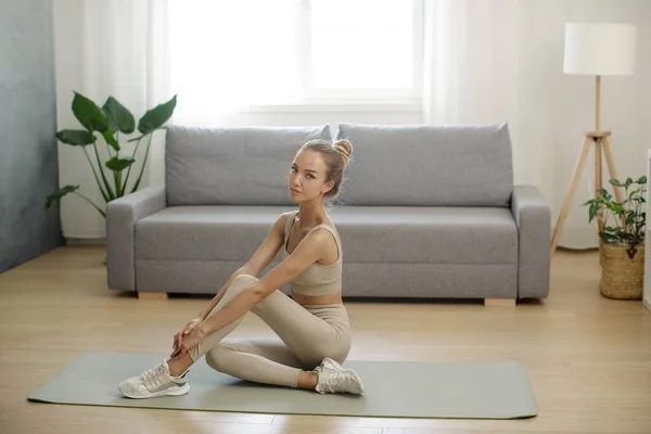 Спортивная женщина на коврике для йоги дома — стоковое фото