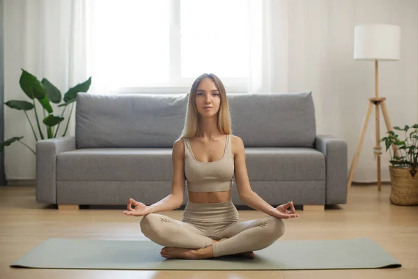 Mulher em meditação no tapete de ioga em casa — Fotografia de Stock
