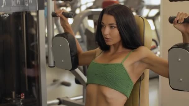 Mulher fitness no ginásio fazendo treino no peito de borboleta na máquina de mosca fitness — Vídeo de Stock