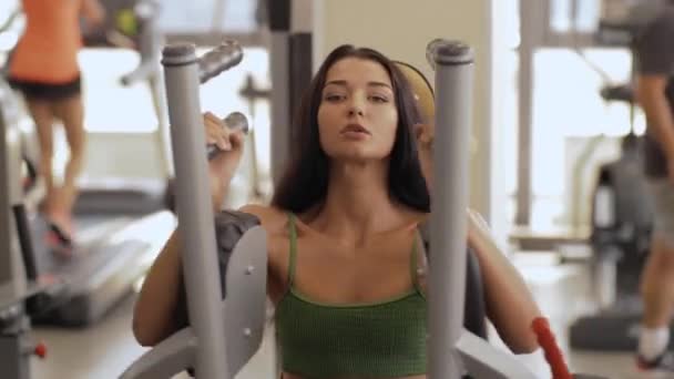 Mujer fitness en el gimnasio haciendo ejercicio de pecho de mariposa en la máquina de volar fitness — Vídeos de Stock