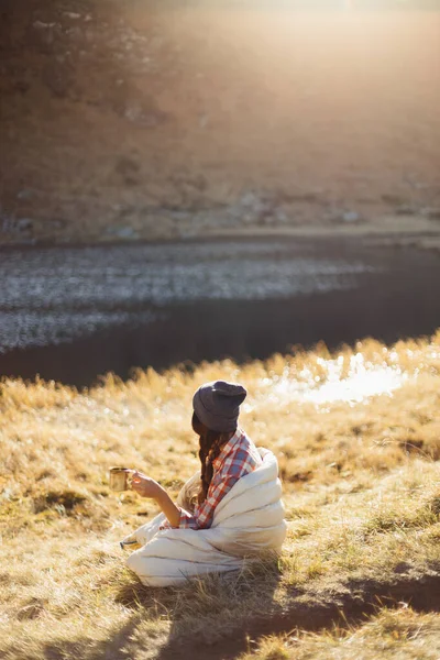 Подорожуюча жінка подорожує в горах з кавою біля озера — стокове фото