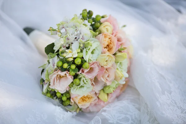 Brautstrauß auf Brautkleid — Stockfoto