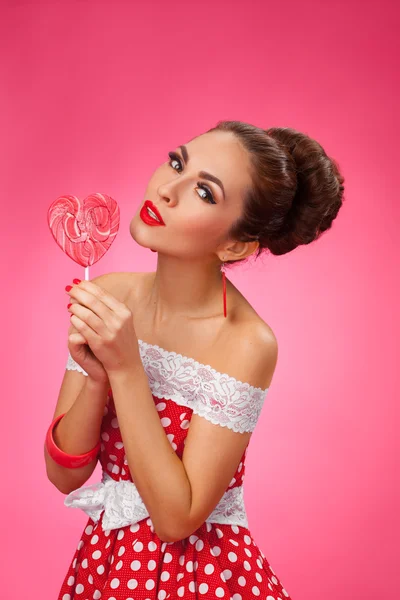 Gelukkig vrouw Holding rode lolly vorm van hart. Pin-up retro stijl. — Stockfoto