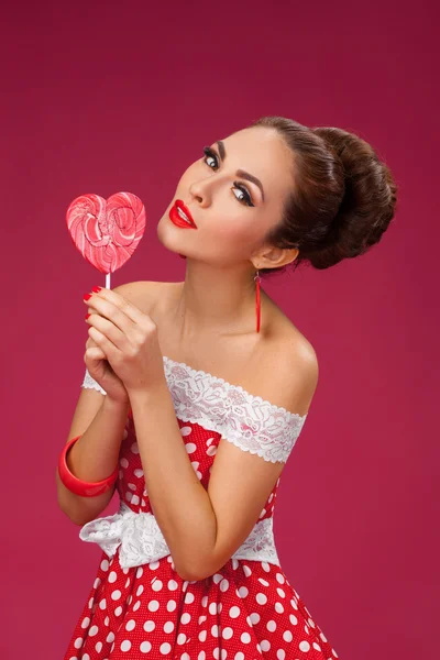 Mutlu kadın kırmızı Holding lolipop şekli, kalp. Pin-up retro tarzı. — Stok fotoğraf