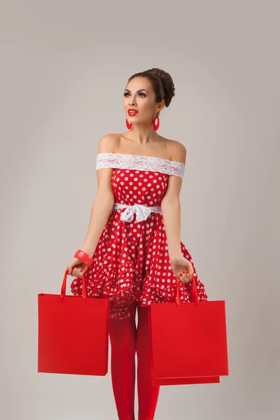 Happy Woman Holding Up Shopping Bags. Pin-up retro style. — Stock Photo, Image