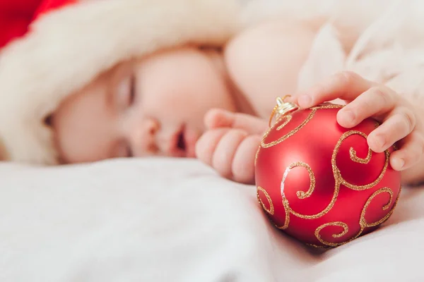 Petit garçon dormant dans une casquette du Nouvel An, se concentrer sur la main — Photo