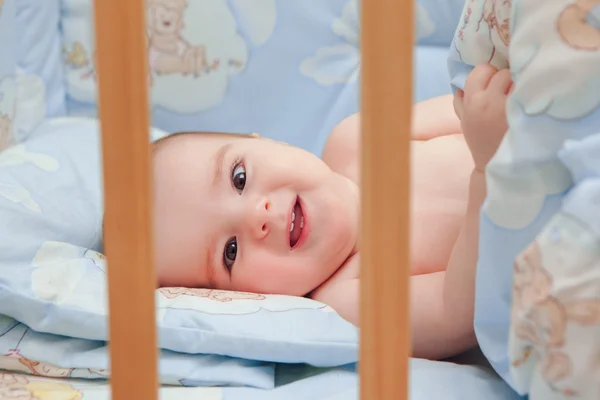 Kleine kind baby lacht in bed — Stockfoto