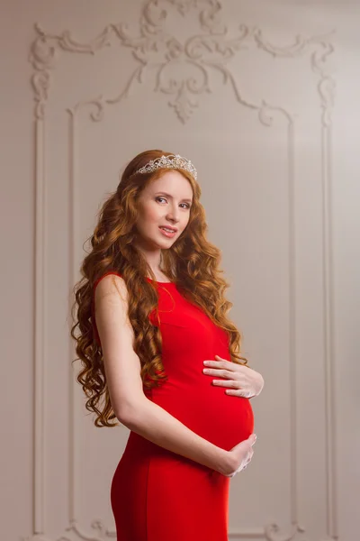 Kırmızı elbiseli hamile kadın. — Stok fotoğraf