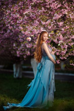 Rahatlatıcı ve doğa hayatta zevk genç hamile kadın