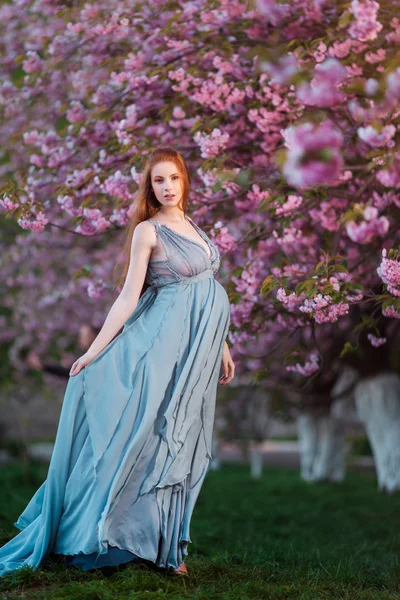 Beautiful pregnant woman in blooming garden — Stock Photo, Image