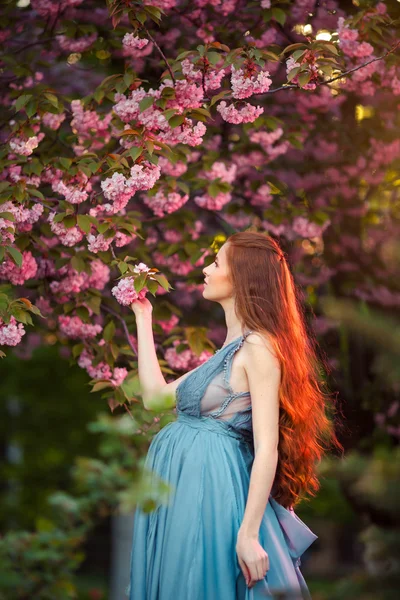 Schöne schwangere Frau im blühenden Garten — Stockfoto