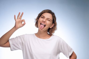 Beyaz tişörtlü oyuncu genç bir kadın arka planda 