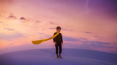 Küçük Prens gibi giyinmiş genç bir çocuk gün batımında sakin bir çölde yalın ayak duruyor, sarı bir eşarp takıyor. Fantezi ve hikaye anlatma temaları için mükemmel tuhaf ve sembolik bir sahne.. 