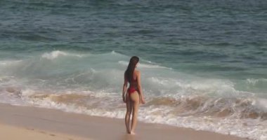 Büyük bir dalganın sahile bir bikini modelini yavaş çekimde sıçratmasıyla eğlenceli bir yaz anıydı. Yüksek kalite, enerjik konsept eğlence, seyahat ve güzellik yaşam tarzı promosyonları için mükemmel..