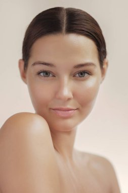 Kusursuz bir cildi ve kendine güvenen bir ifadesi olan bir kadının stüdyo görüntüsü. Cilt bakımı, yüz ürünleri, sağlık içeriği veya doğal kozmetik markalaşma için ideal.