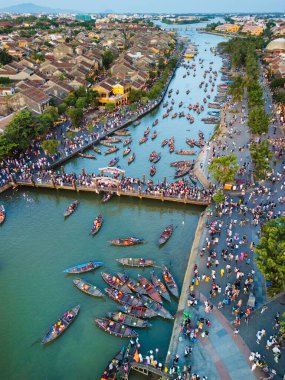 Yüksek kalitede bir drone fotoğrafı ikonik Hoi 'yi yakalıyor yukarıdan bir fener festivali - canlı bir nehir sahnesi, kültürel cazibe ve kalabalık - seyahat alanları ve stok kullanımı için mükemmel.