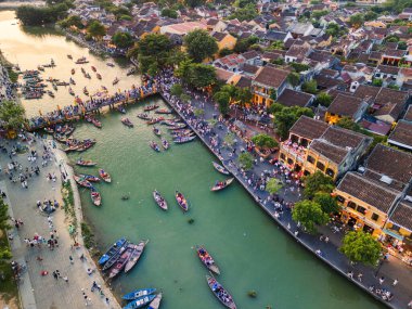 Hoi An, Vietnam 'ın renkli hava görüntüleri fener teknelerini, tarihi binaları ve altın saatinde kalabalık nehir yürüyüşlerini gösteriyor. Kültürel turizm, hedef tanıtım veya seyahat reklamları için ideal.