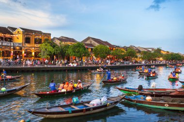 Hoi Ans 'ın UNESCO miras sitesinden canlı bir sahne. Turist kalabalığı Antik Kenti keşfediyor ve Thu Bon Nehri 'nde geleneksel örneklere biniyor. Mükemmel bir kavramsal seyahat reklamı..
