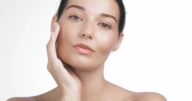 Muhteşem model, sakin ve kendinden emin bir şekilde ışıldayan tenine nazikçe dokunur. Lüks cilt bakımı kampanyaları, yüz bakımı tanıtımları, öz-aşk içeriği ve rafine markalaşma için ideal..