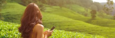 Romantic vlogger traveler woman sharing photos and videos with mobile phone app her travel vacation to famous nature landmark tea plantations in Sri Lanka. Gen Z talent happy girl influencer making