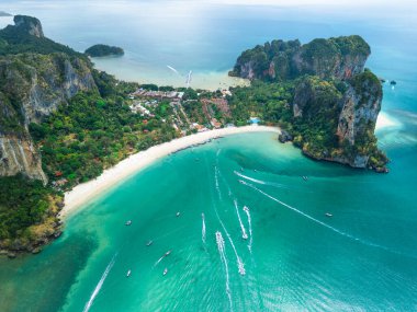 Tayland, Krabi 'deki Railay ve Phra Nang plajlarının hava fotoğrafı. Turkuaz denizi, kayalıkları, tekneleri ve tropikal manzarayı gösteriyor. Turlar, seyahat reklamları ve plaj tatilleri için ideal..
