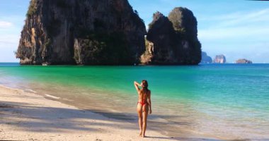 Kafkas bikini modeli Phra Nang Sahili, Krabi, Tayland 'da tropikal kaçışın keyfini çıkarıyor. Manzaralı turkuaz sular ve kireçtaşı kayalıklar bu çarpıcı seyahat ve yaşam tarzı kavramını vurguluyor.