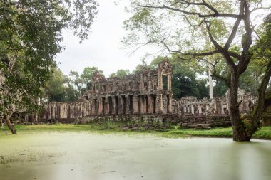 Preah Khan Tapınağı Khmer galerisi alglerle kaplı hendek ve orman ağaçlarının ötesinde, Angkor, Kamboçya 'da sabah ışığında ele geçirildi. Kültür turizmi, eğitim ve reklamlar için yüksek kaliteli imaj.