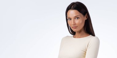 Güzel atletik kadın bej rengi etek giyip güçlü ve kendine güvenen bir poz veriyor. Kavramsal spor ve spor yaşam tarzı portresi, sağlık, spor salonu, promosyon ve yüksek kaliteli