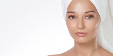 Parlayan ten, temiz güzellik konsepti: beyaz stüdyo arka planında havlu türbanlı genç beyaz kadın pozu. Cilt bakımı, kaplıca ve sağlık reklamları için yakın plan portre, dış ticaret için yüksek kaliteli pankart.