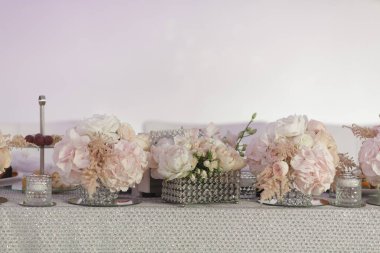 Lüks düğün tatlı masası allık rengi şakayık süslemeler ve ışıl ışıl çarşaflarda kristal vazolar. Zarif etkinlikler, tanıtım afişleri, arka planlar ve dekor fikirleri için kavramsal görüntü.