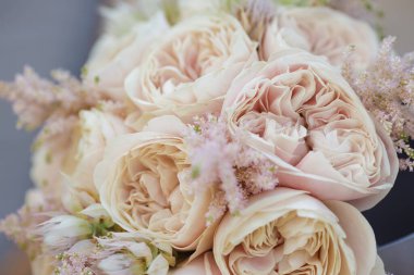 Lavanta aksanıyla karıştırılmış zarif allık renkli bahçe güllerinin detaylı görüntüsü. Düğünler, romantik etkinlikler ve tasarım ya da dekor projeleri için mükemmel kaliteli çiçek aranjmanı.