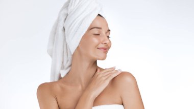 Havluya sarılı güzel bir Asyalı kadın omzuna hafifçe dokunurken gözleri kapalı gülümsüyor. Yüksek kalite güzellik, cilt bakımı ve kozmetik, sağlık ve yaşam tarzı tanıtımı için spa portresi konsepti