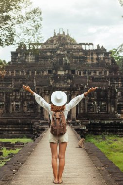Baphuon Tapınağı geçidi, Kafkasyalı sırt çantalı Angkor Thom, Kamboçya 'da kollarını kaldırarak kutluyor. Seyahat reklamları, makaleler ve rehberler için kavramsal, yüksek kaliteli görüntü. Turizm kampanyaları için ideal.