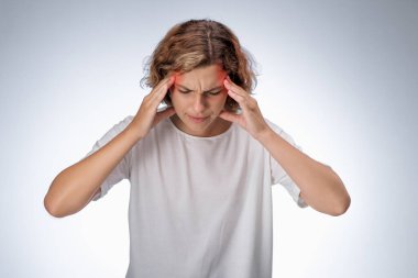 Beyaz gömlekli genç bir kadın şakaklarını kapalı gözlerle ve acı dolu bir yüzle bastırıyor. Kırmızı izler şiddetli baş ağrısı ya da migren olduğunu gösteriyor. Sağlık, stres ve tıbbi kavramlar için ideal.