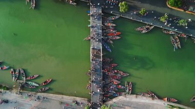 Hoi An, Vietnam 'daki ikonik köprünün etrafındaki fener teknelerinin havadan görüntüsü. Geleneksel Asya atmosferli seyahat, kültür mirası ve turizm için ideal.